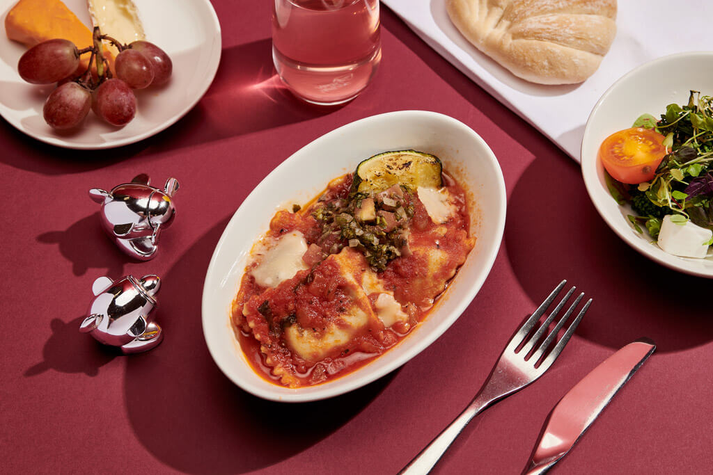 Basil and ricotta ravioli with tomato sauce, roasted baby courgette shaved hard italian cheese and salsa verde   