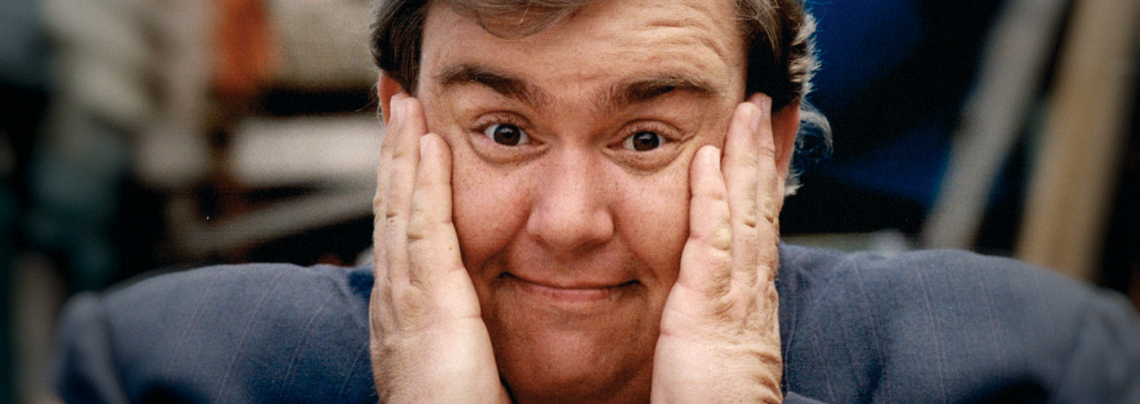 John Candy with his hands on his face