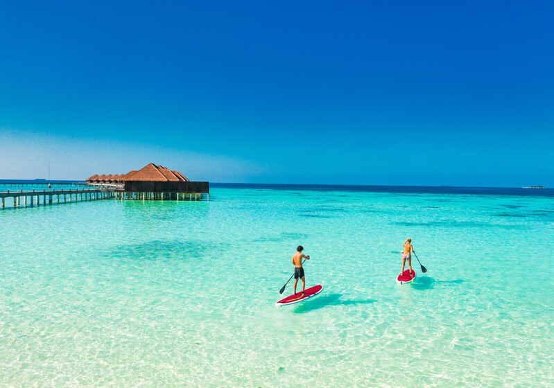 Couple paddle boarding in the Maldives
